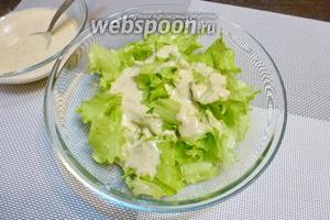 Листья салата (штуки 3) крупно рвём, кладём в миску и заливаем соусом, тщательно перемешаем, чтобы все листья обволокло соусом.