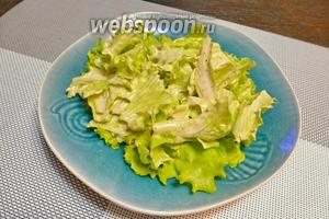 Собираем салат. В порционную тарелку выкладываем листья салата с соусом.