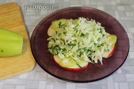 Выложить на плоскую тарелку дольки яблока, перец, внутрь нарезанные овощи с яблоком.