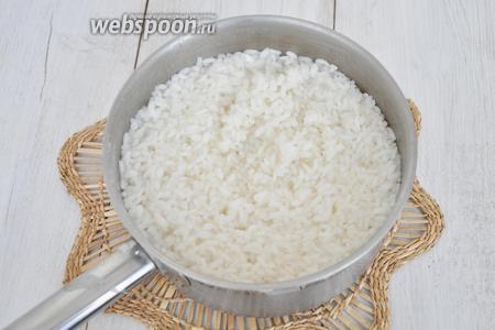 Рис залить водой (в пропорции 1х1.5), довести до кипения и снять с огня. Закрыть плотно крышкой. Через 15 минут рис разбухнет и впитает воду, будет почти готов. Промыть.